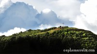 Sunlight hits a cross-topped hill, Cusco, Peru photo