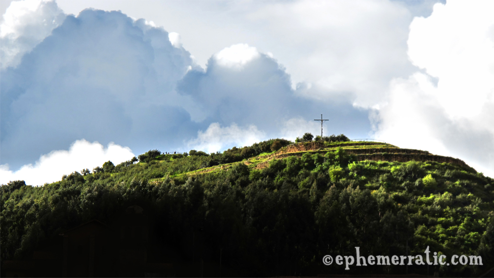 Sunlight hits a cross-topped hill, Cusco, Peru photo
