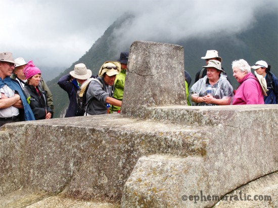 Tour group looks at Intihuatana sculpture, Machu Picchu, Peru photo