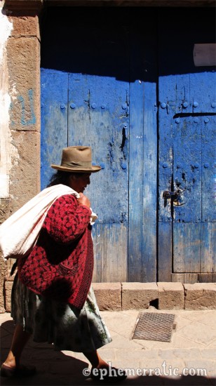 Quechua woman walks through Pisac's old town, Peru photo